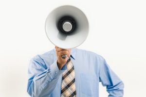 Mieux informer pour vendre en ligne : Un homme parle dans un mégaphone
